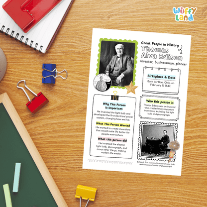A children's educational worksheet about Thomas Alva Edison laid flat on a wooden desk, surrounded by school supplies including a red notebook, blue pen, binder clips, chalkboard, and eraser. The worksheet has colorful borders, text boxes, and photos of Edison.