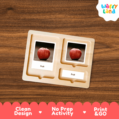 A wooden Montessori-style activity tray with two slots holding printed apple cards labeled 'fruit,' shown on a wood-grain surface. The Wuffy Land logo appears in the top right, and a red banner at the bottom reads 'Clean Design,' 'No Prep Activity,' and 'Print & GO.