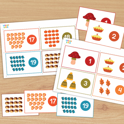Set of printable counting cards on a wood background featuring autumn icons—mushroom, apple pies, leaves, trees, hedgehogs, foxes, and books. Each card shows a group of items with a large numeral in a colored circle (e.g., 1, 2, 8, 9, 17, 19), designed to practice counting numbers 1–20.