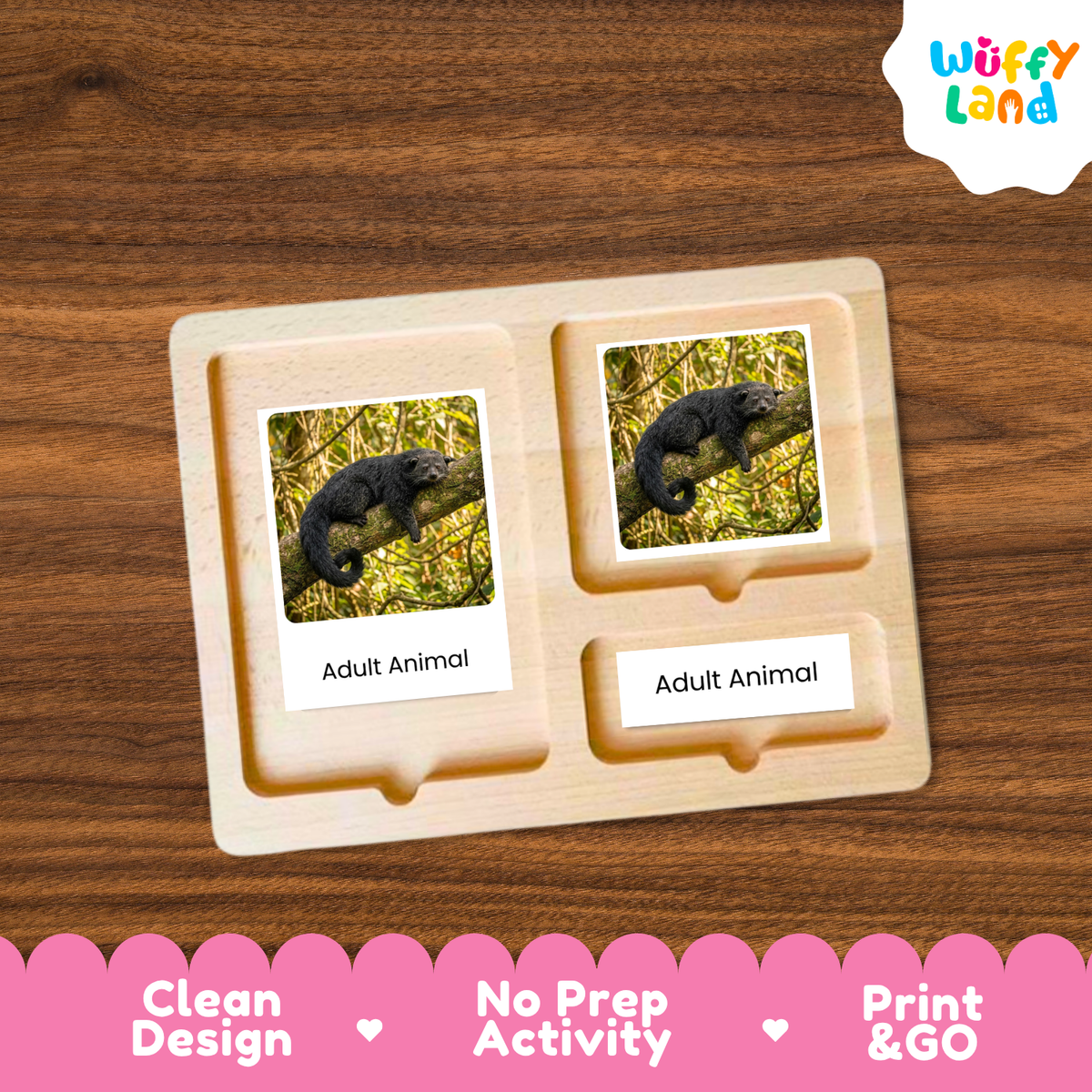 A wooden Montessori-style activity board with two labeled slots reading 'Adult Animal' and printed photos of a dark animal in grass, shown on a wood-grain background. A 'Wuffy Land' logo appears in the top right, and a pink banner at the bottom highlights 'Clean Design', 'No Prep Activity', and 'Print & GO'.