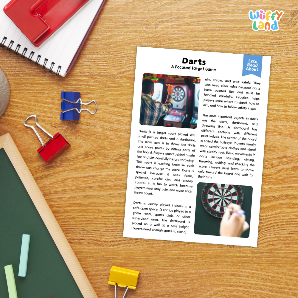A printed educational worksheet about the game Darts, laid flat on a wooden desk with a red spiral notebook, blue binder clips, and a green folder nearby.