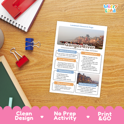 A printed Ganges River landmark research page activity sheet lies on a wooden desk, surrounded by school supplies including a red notebook, blue binder clips, and a green chalkboard. The sheet has a clean design with a city photo at the top and text sections about the Ganges River.