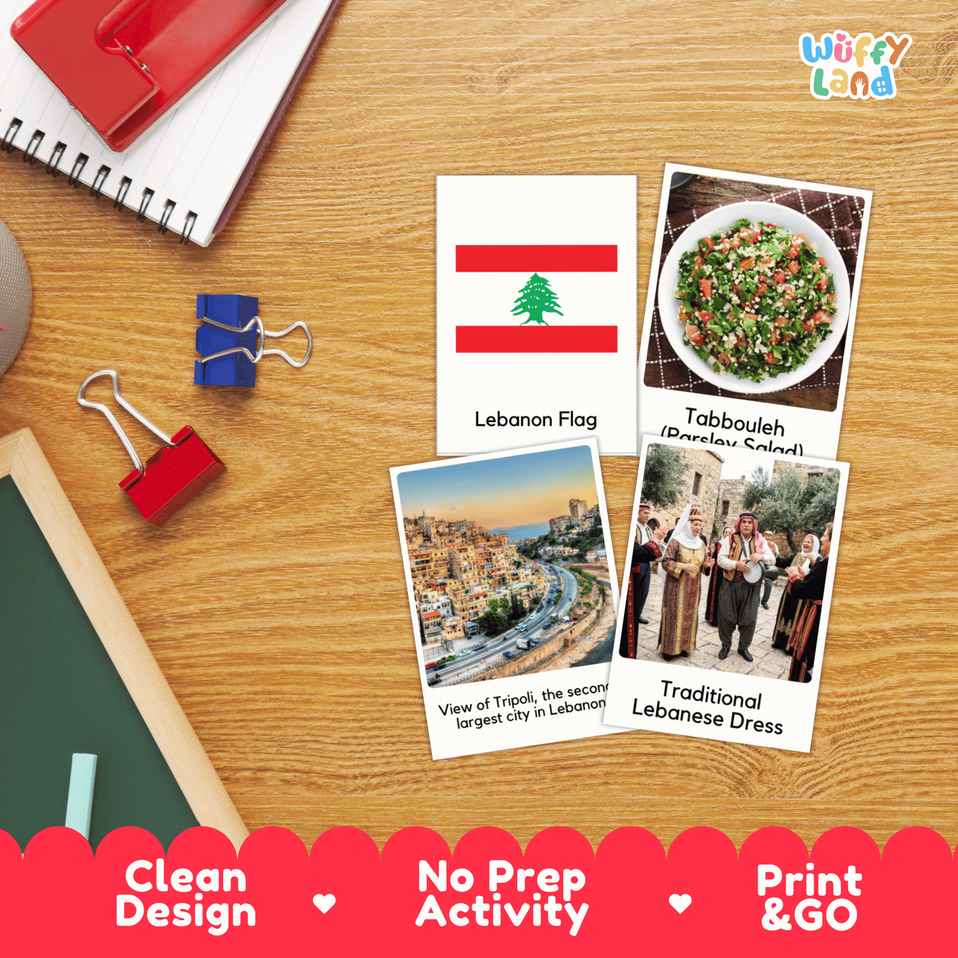 Four educational activity cards about Lebanon are displayed on a wooden desk with school supplies. The cards feature the Lebanon flag, a tabbouleh salad photo labeled 'Tabbouleh', a view of Tripoli labeled 'View of Tripoli', and traditional Lebanese clothing labeled 'Traditional Lebanese Dress'.