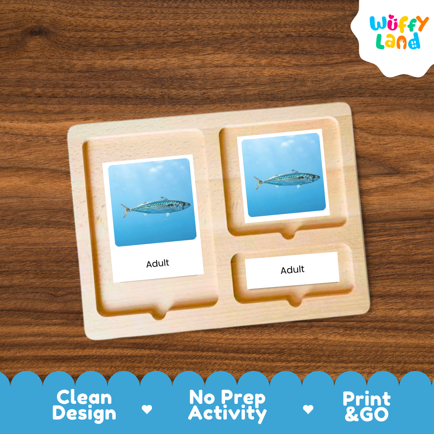 A wooden activity board with two labeled slots reading 'Adult' and a smaller slot, each containing a blue card with a fish illustration, shown on a wood-grain background. A 'Wuffy Land' logo appears in the top right, and a blue promotional banner at the bottom lists 'Clean Design', 'No Prep Activity', and 'Print & GO'.