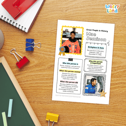 A printed educational poster about Mae Cemonison lies on a wooden desk, surrounded by school supplies including a spiral notebook, binder clips, chalk, and a red folder. The poster has text sections and small photos of Mae Cemonison in space suits.