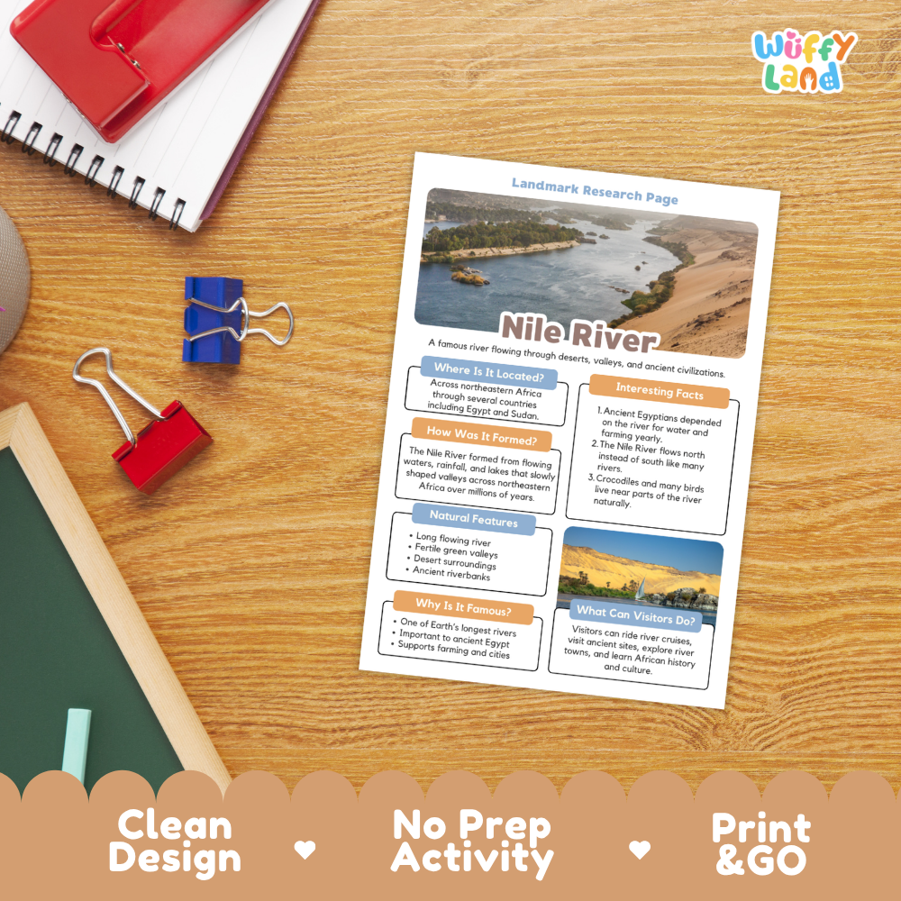A printed activity sheet titled 'Landmark Research Page' about the Nile River lies on a wooden desk, surrounded by school supplies including a spiral notebook, binder clips, and a red folder. The sheet has colorful text boxes and small landscape photos.