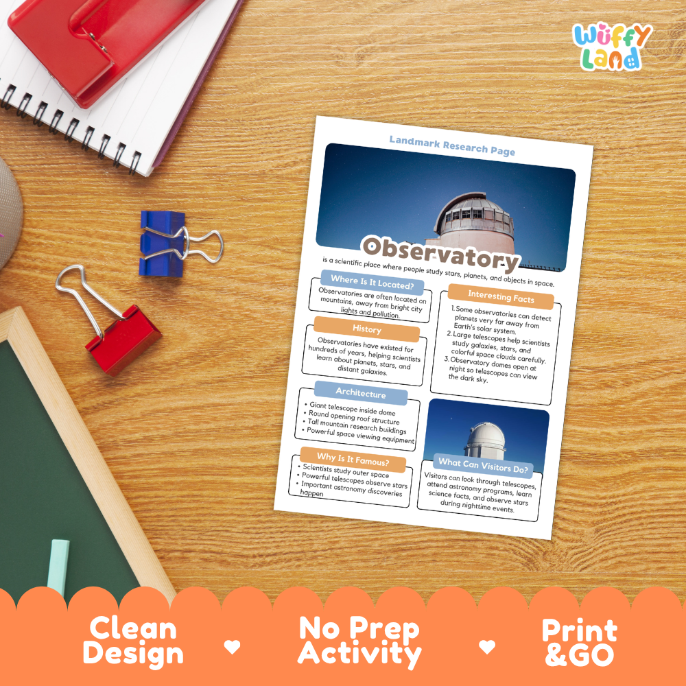 A printed observatory-themed activity sheet laid on a wooden desk with notebooks, binder clips, and a chalkboard nearby. The sheet has a blue header with an observatory photo and text sections about an observatory.