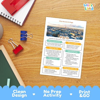 A printed Paris city research page template shown on a wooden desk with school supplies around it. The page includes a city map photo, headings, and colored text boxes for activities.