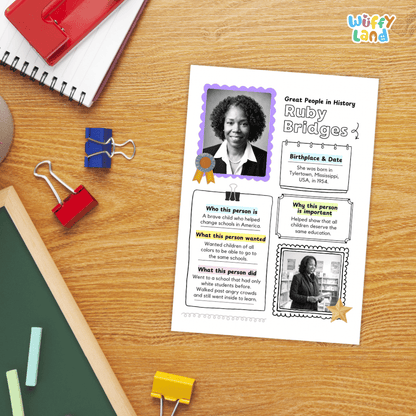 A printed educational poster about Ruby Bridges laid on a wooden desk, surrounded by school supplies including a spiral notebook, binder clips, chalk, and a red folder. The poster has photo frames, text boxes, and decorative accents.