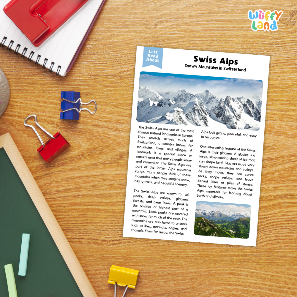 A printed educational worksheet titled 'Swiss Alps' laid on a wooden desk with binder clips, notebooks, and a red notebook around it. The sheet includes text, a blue header, and small landscape photos related to Swiss Alps scenery.