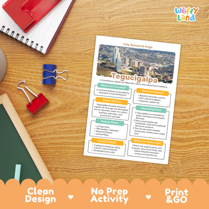 A printed city research page about Tegucigalpa is laid on a wooden desk with school supplies around it. The page has a city skyline photo at the top and text sections about the city, styled like an activity sheet.