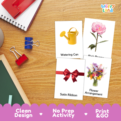 Four printable activity cards laid out on a wooden desk, showing simple illustrations and labels: a yellow watering can, a pink flower, a red satin ribbon, and a flower arrangement. The cards are part of a school-themed flat lay with notebooks, binder clips, and a chalkboard visible around them.