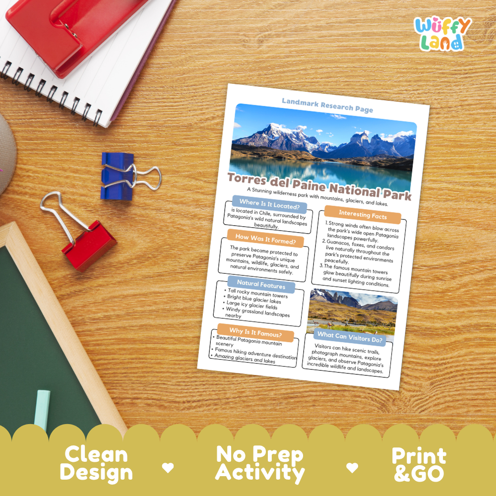 A printed activity sheet titled 'Landmark Research Page' for Torres del Paine National Park, laid on a wooden desk with a spiral notebook, binder clips, chalk, and a red folder nearby. The sheet includes a mountain landscape photo and text sections.