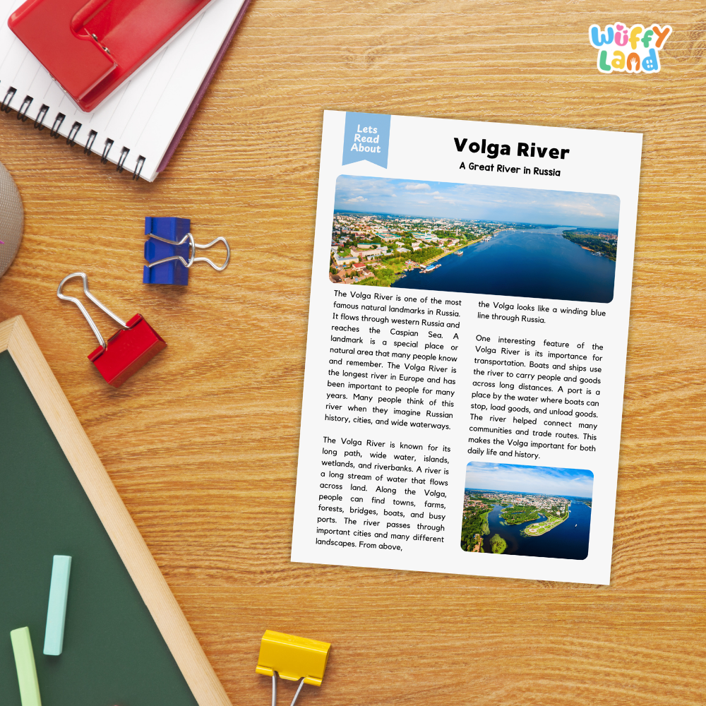 A printed educational worksheet titled 'Volga River: A Great River in Russia' with two landscape photos and text, placed on a wooden desk among notebooks, a red notebook, blue and red binder clips, and a green folder. The 'Wiffly' brand logo appears in the top right corner.