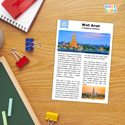 A printed travel-style informational card about Wat Arun laid on a wooden desk, surrounded by school supplies including a red notebook, blue binder clips, a green folder, and binder clips. The card has a headline 'Wat Arun' and a small scenic photo of the temple.